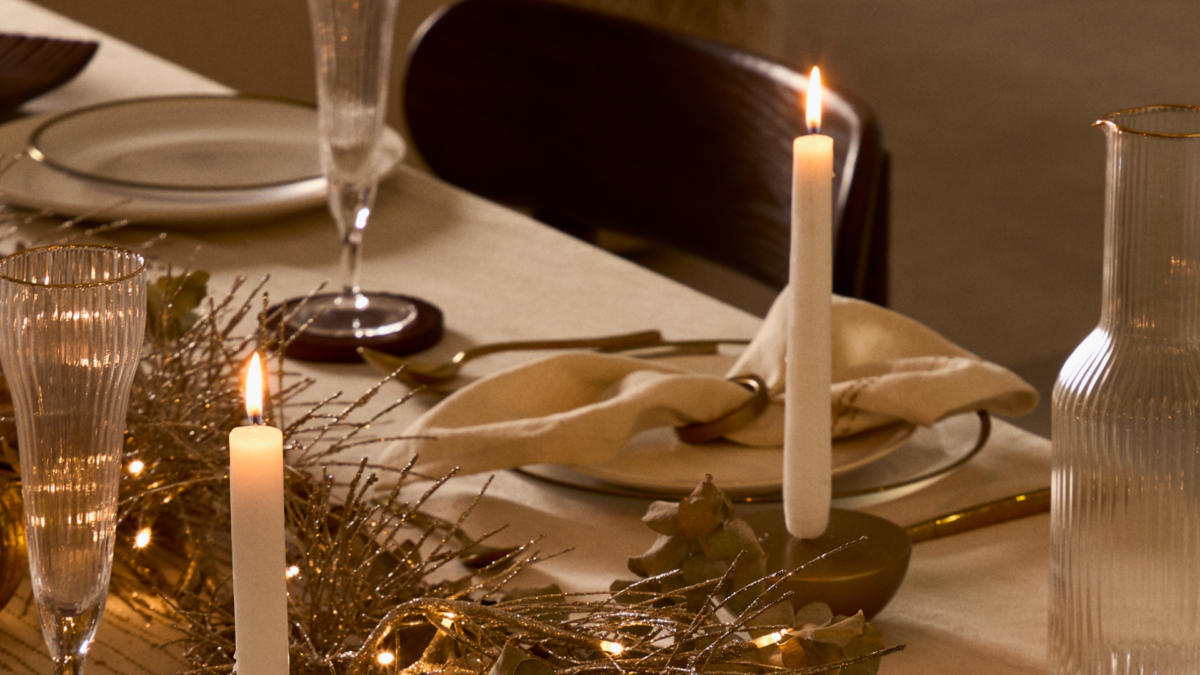 Mesa decorada de navidad con textiles blancos, velas y vajilla elegante